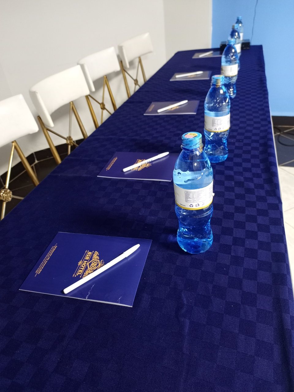 818 notepads, pens and water laid out for a meeting