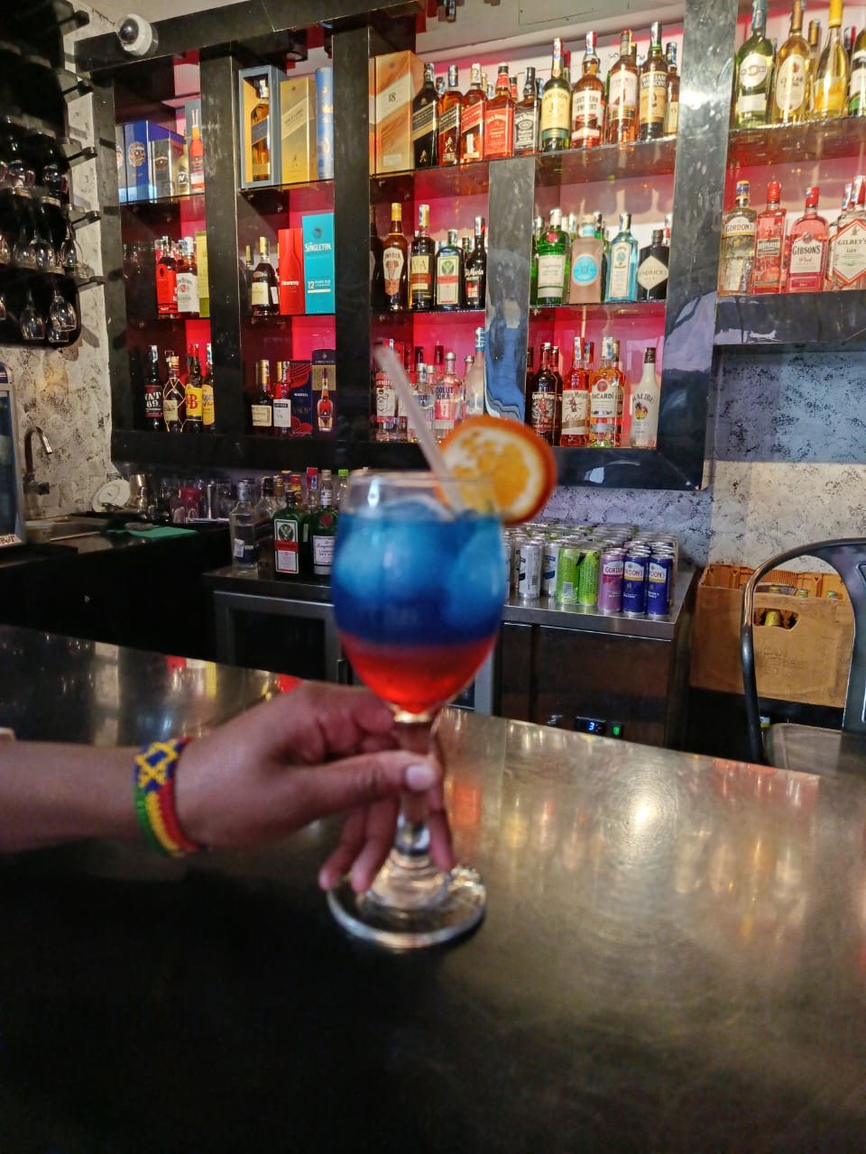 A layered blue and red cocktail at the bar