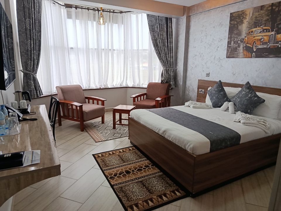 A suite with a bay window, two armchairs and a desk