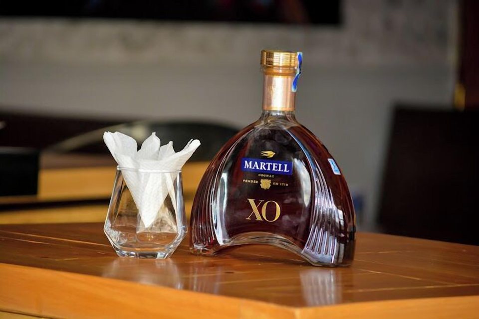 A bottle of cognac with a glass in the VIP lounge